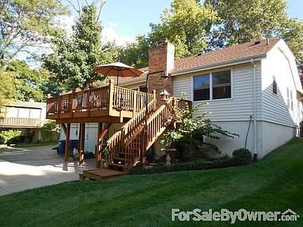 Back of home : Newly stained 14X20 deck with two wrought iron insets. Tree through deck.