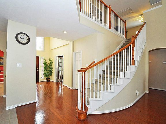 GLEAMING HARDWOODS IN ENTRY LEAD TO CURVING STAIRCASE