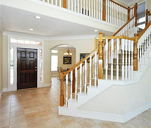 Light and bright entry with high ceiling and upgraded neutral tile flooring