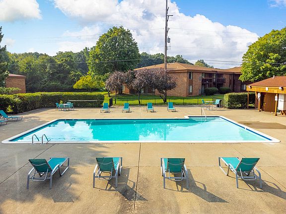 Heated pool equipped with comfy lounge chairs at Westwood Village Apartments in Westland, MI