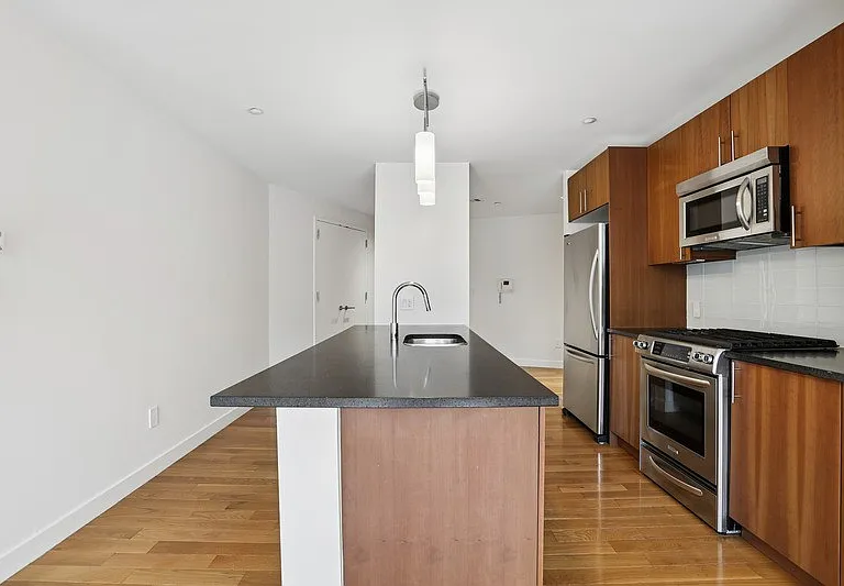 Elevate your lifestyle at Arbor with this stunning kitchen featuring sleek stainless steel appliances and rich wooden accents. Ideal for culinary enthusiasts, the open layout fosters both functionality and style. Schedule your tour today!