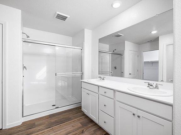 The master bathroom has a step in shower and large dual sink vanity.