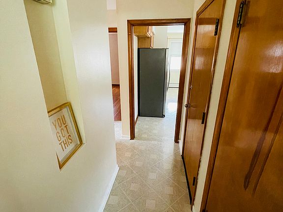 Hallway connecting all the rooms, large storage closet on the right, and rear door closest to the kitchen.
