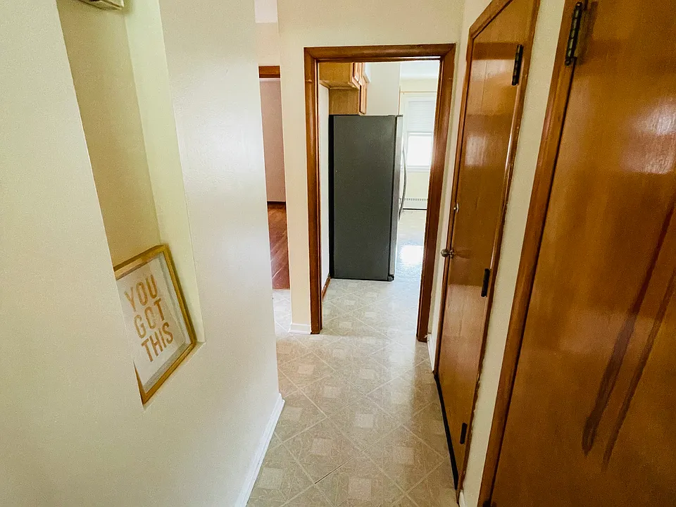 Hallway connecting all the rooms, large storage closet on the right, and rear door closest to the kitchen.