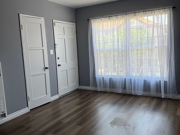 Living room with new flooring, paint, and window covering