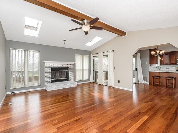 Vaulted beam great room with gas fireplace and very open to the kitchen.  Look at those stunning floors!