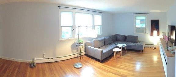 Large, sunny living room with hardwood floors throughout unit.