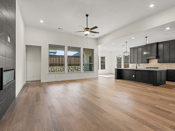 Open concept living room and kitchen in a modern tudor style home by Kindred Homes