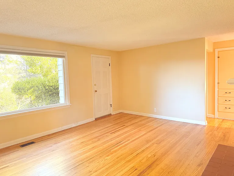 Living room: Large picture window, door that leads to small breezeway and deck.