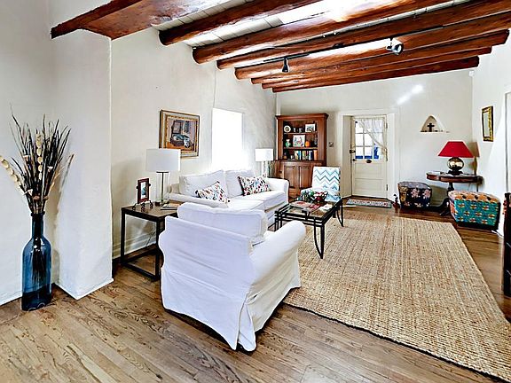 Hardwood floors and vigas complement crisp white furnishings in the living room.