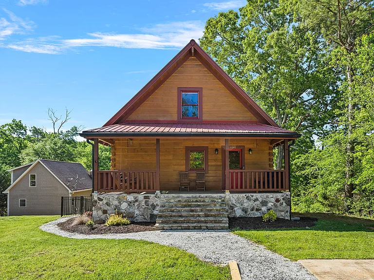 Front of house with covered porch and hanging wooden swing.