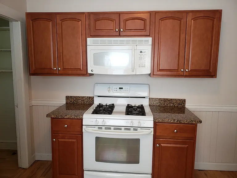 Gas stove with microwave oven above, plus full set of cabinets over and on the sides of the stove