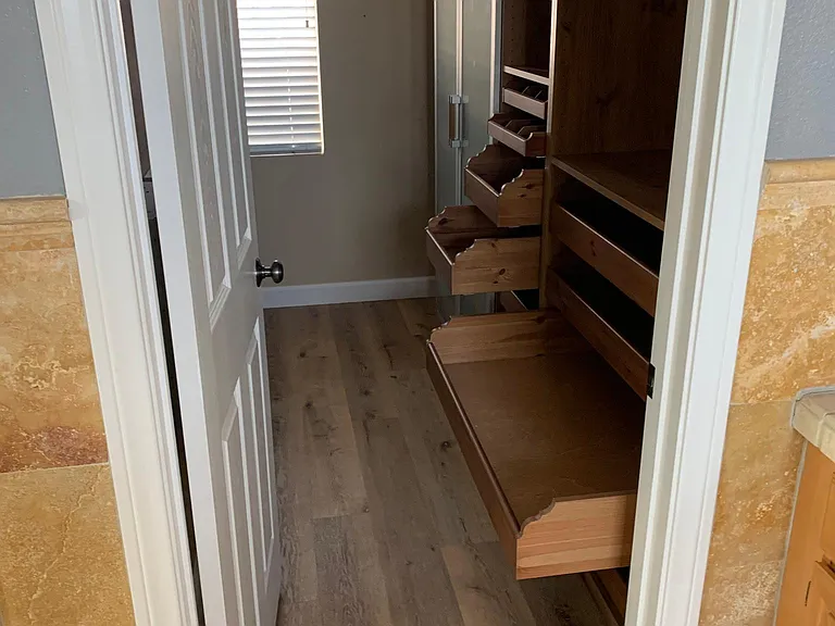 master closet. additional storage and hanging cabinet and drawers around corner at left