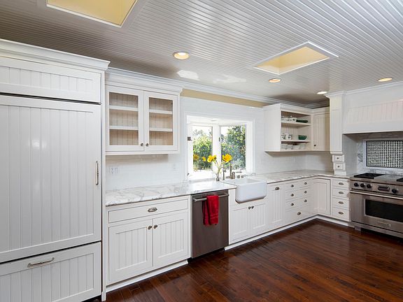 Fully equipped kitchen with gas stove and stainless dishwasher. Natural light from the window that overlooks lush landscaping