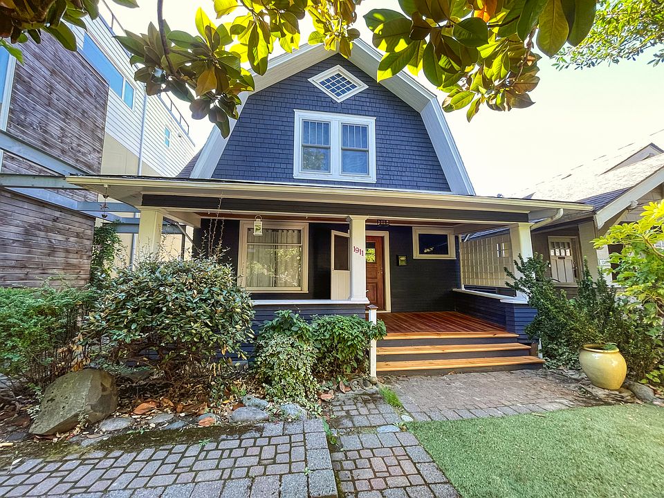 Front of house -- charming windows, huge front porch, artificial turf, lovely plants