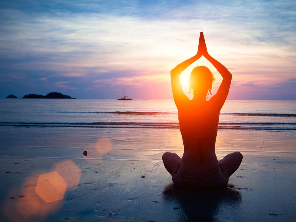 Woman Doing Yoga Pose on Beach at Sunset