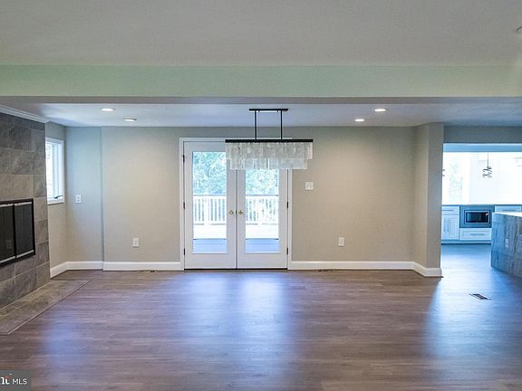 Open layout formal dining room with marble wood burning fireplace. French doors lead to grand 2 story deck.