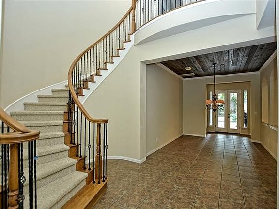 Entry foyer showing winding staircase and view of dining room