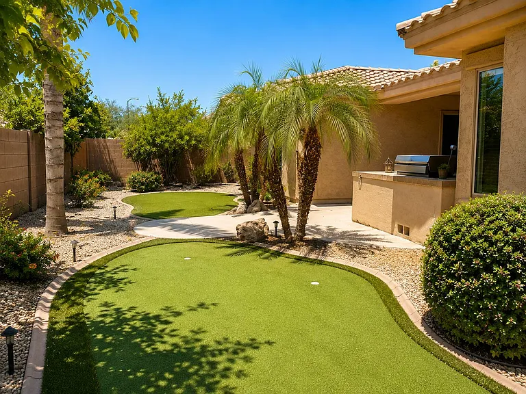 Landscaped backyard with putting green, paved patio, and built-in outdoor grillideal for relaxing or entertaining.