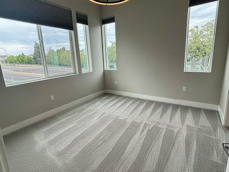 Large primary bedroom with ample lighting and upgraded lighting and blinds.