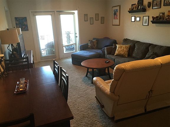 Living room with cathedral ceiling, ceiling fan, and access