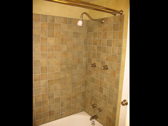 Newly tiled bathroom wall, new tub.
