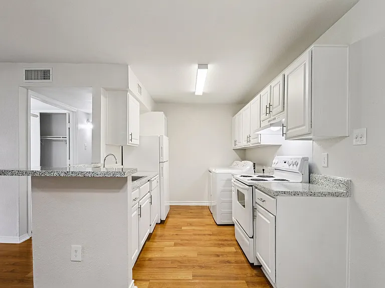 Bright, modern kitchen featuring white cabinetry, sleek countertops, and elegant wood-style flooring. Bright, modern kitchen featuring white cabinetry, sleek countertops, and elegant wood-style flooring.