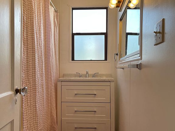 Updated main floor bath with tub shower combo to left and toilet behind door.