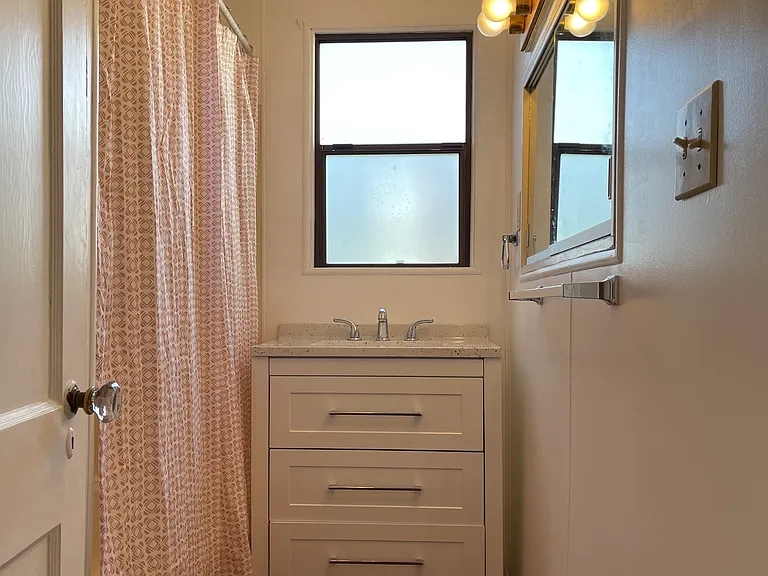 Updated main floor bath with tub shower combo to left and toilet behind door.