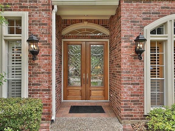 You will welcome your guests through the double entry doors with glass insets. The coach lights add an elegant touch and the tiled reception area is just one of many custom features in this home.
