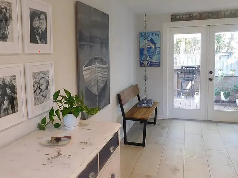 Bonus room with furniture (from previous occupants) showing tiled floors and French doors leading to backyard deck