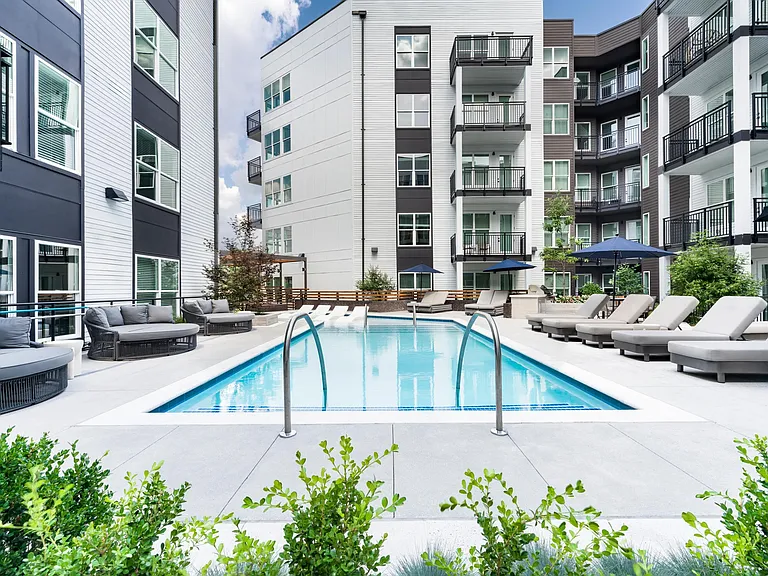 Sun shelf loungers, poolside daybeds, and shaded seating create a refreshing outdoor retreat surrounded by contemporary architecture and Atlanta energy.