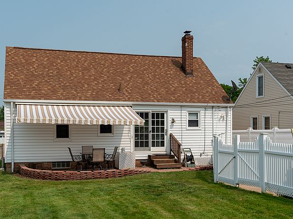 Fenced in back yard with patio and manual sun screen awning