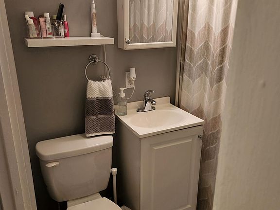 Clean space save bathroom with beautiful marble flooring and new high end tub enclosure.