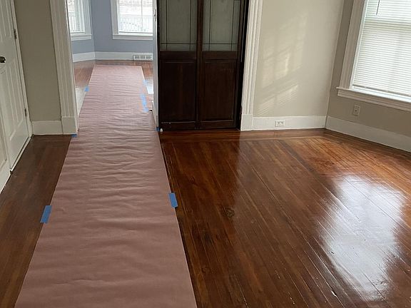 View of living room into bedroom Sliding French doors Refinished hardwood floor New walls, new ceiling, new paint