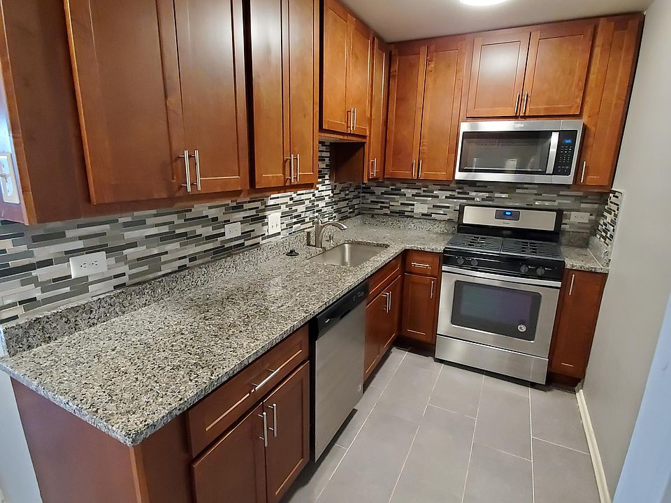 Beautifully renovated kitchen with Auburn cabinets and Caledonia Granite countertops, Grey porcelain floor, Stainless steel appliances.