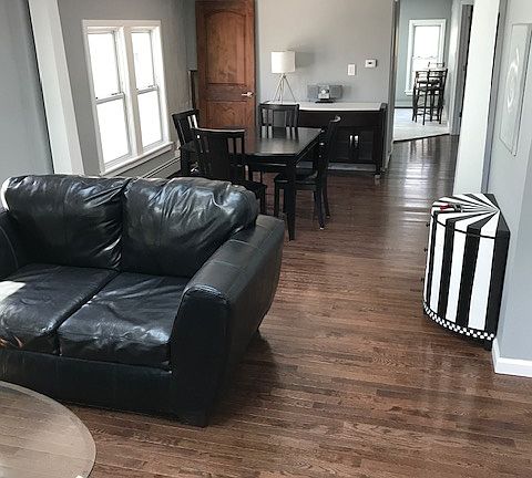 Living room looking into the dining room and kitchen with continuous hardwood floors