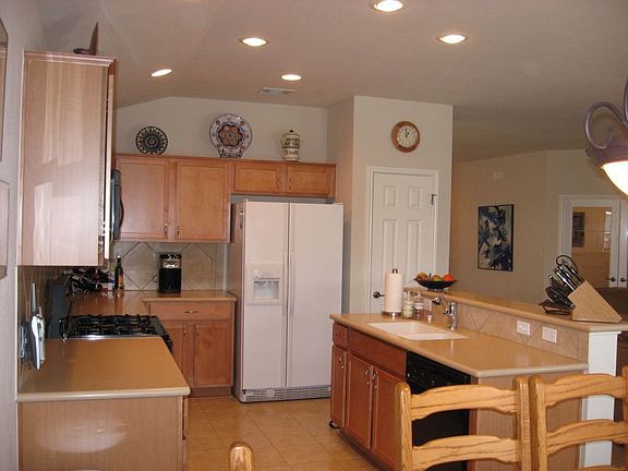 Kitchen with Corian, Tile Back Splash, and Recessed Lighting