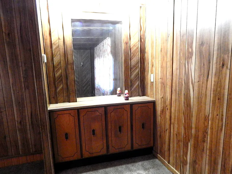 Cabinets with mirror at end of living room