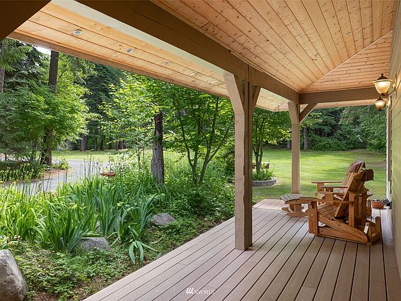 Front covered porch at the entrance, perfect for coffee in the morning with the birds and early evening time. This stunning property is an oasis of peace, wild life and - NO WIND!!>
