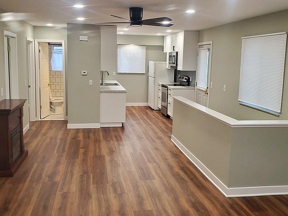 Looking from front door, the 3 bedrooms are along the left side; bathroom and kitchen at the rear, with side door and stairs to basement on the right. Large ceiling fan in main room. New laminate flooring throughout main level.