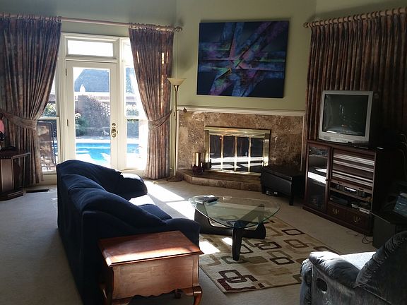 Living room is step-down with vaulted ceiling, fireplace and