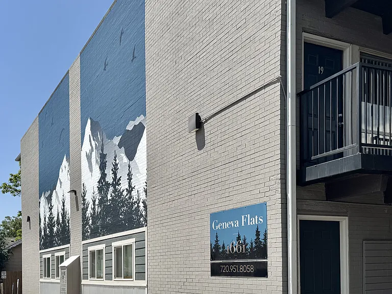 Contemporary apartment exterior with artistic mountain mural at Geneva Flats, featuring balconies and a serene atmosphere.