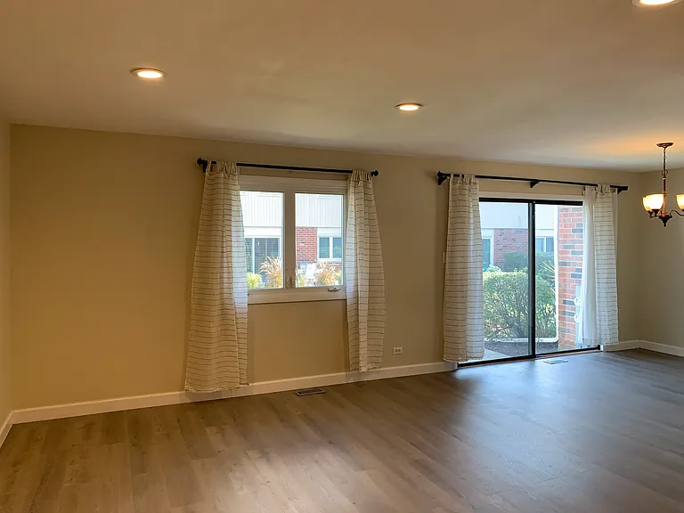 Spacious living/family room w/ one window and a big sliding door to the backyard