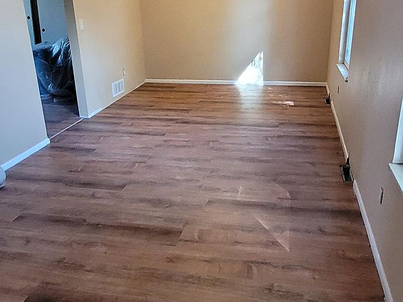 Living room with new flooring, new paint, new ceiling fan.