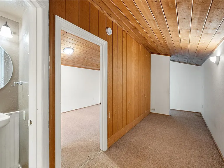 Wide hallway from bathroom leading to the 3 bedrooms