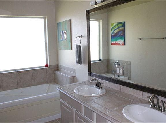 Great master bath has double sinks and jacuzzi tub and frosted glass pane