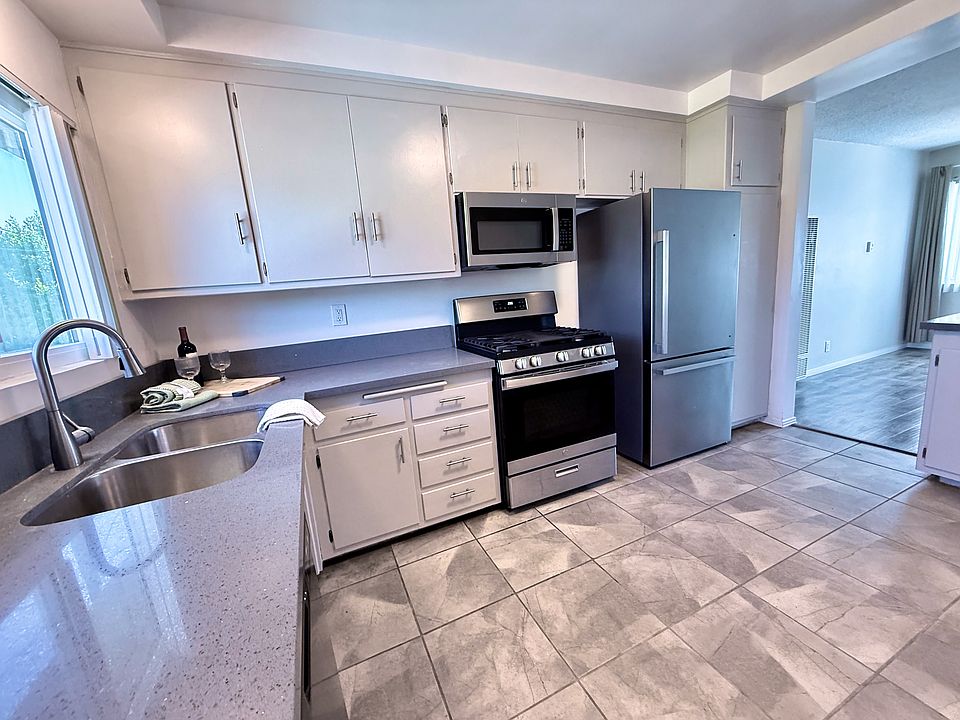 Large Chef's Kitchen with Premium Stainless Steel Appliances and Granite Counters, Italian Tile floors & door to large balcony.