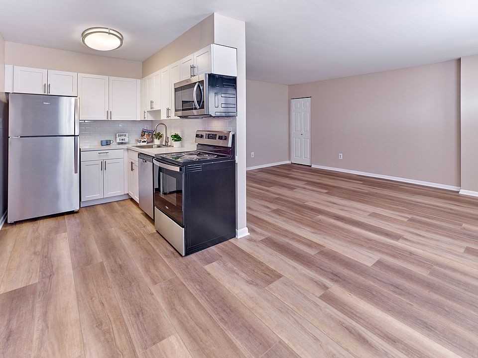 Contemporary kitchen with stainless steel appliances and open living space at Village Square.