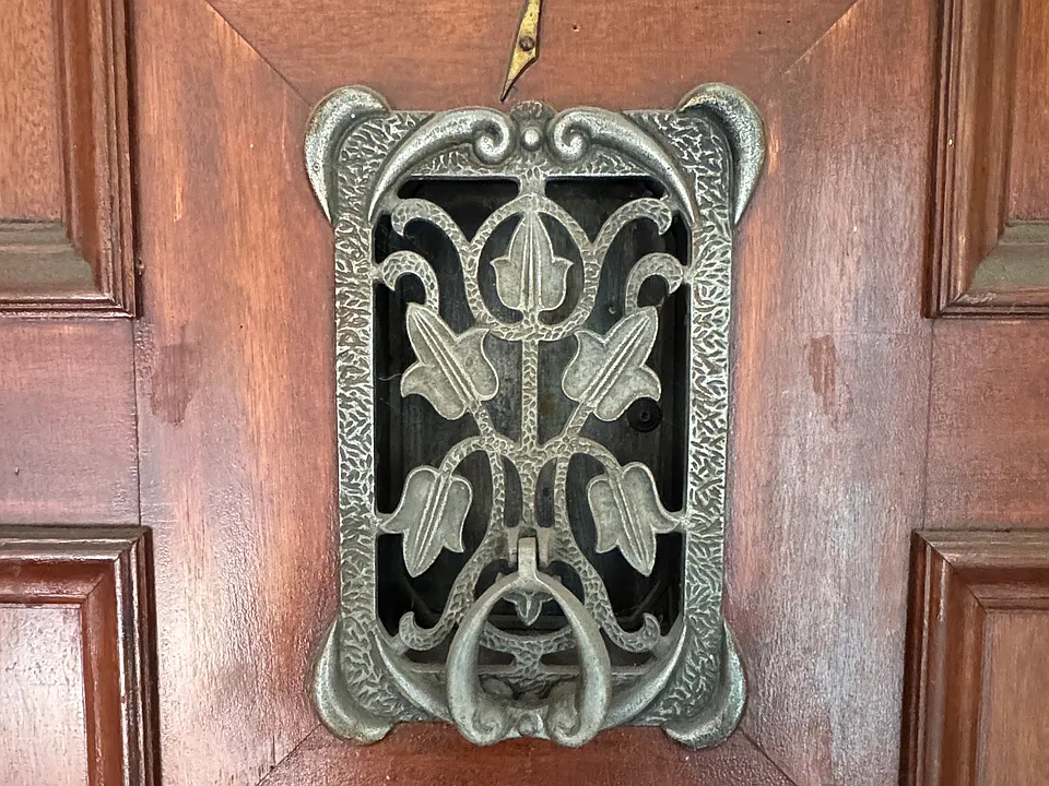 Unit front door with vintage knocker and peekaboo viewer.